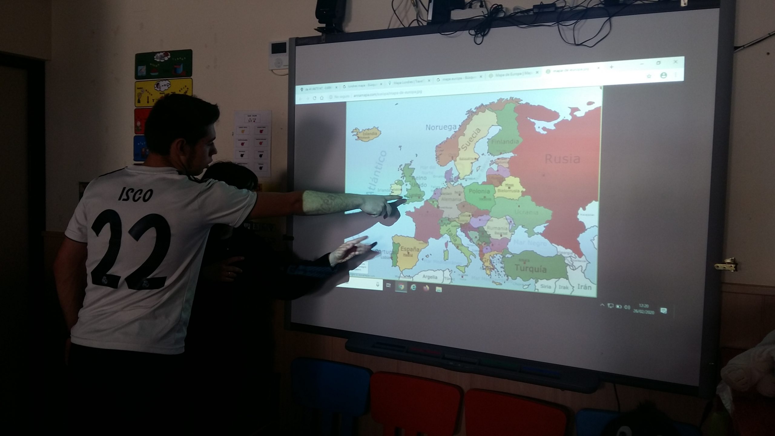 Alumno localizando Londres en un mapa proyectado en la pizarra digital